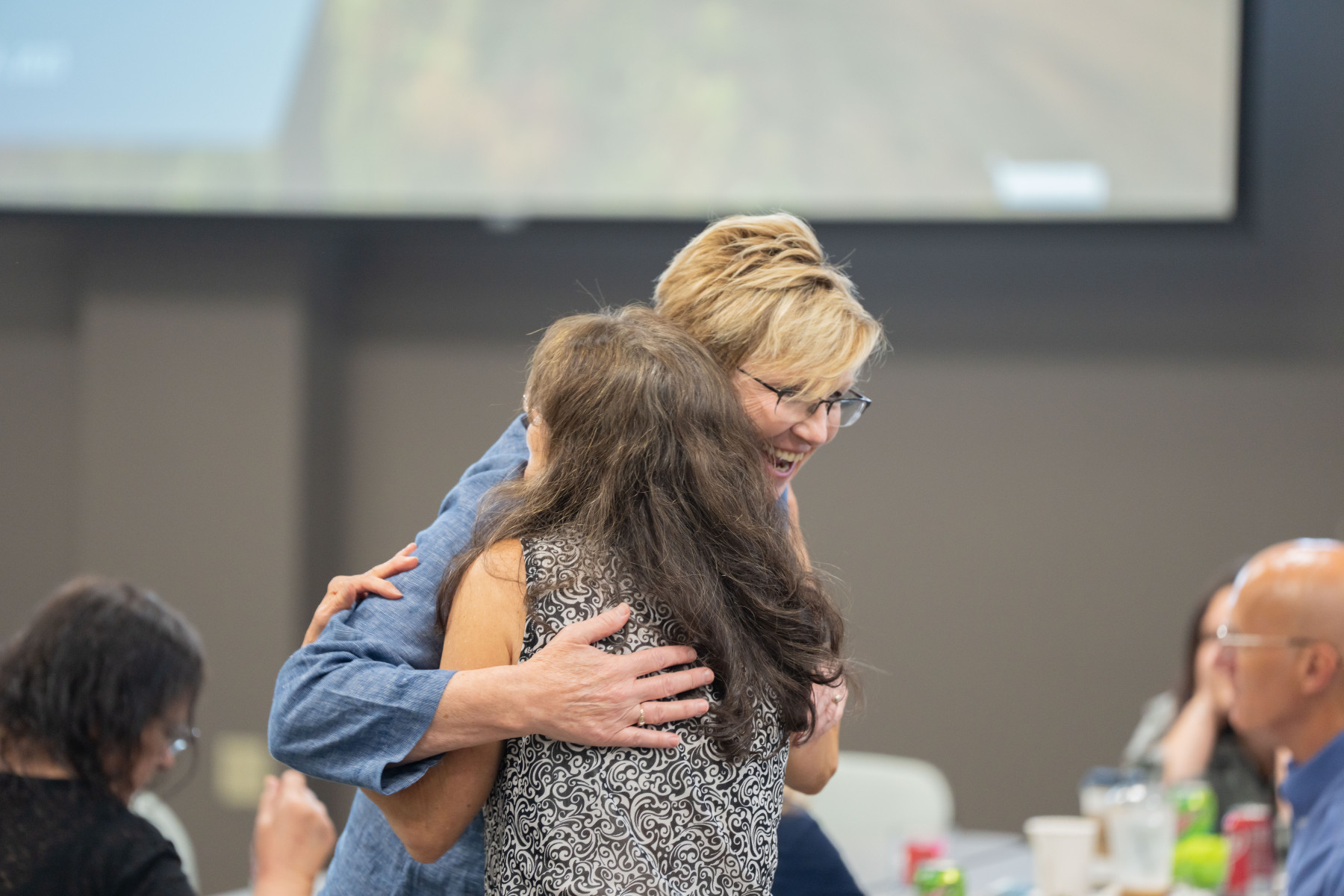 Two people hugging at Impact Funding event
